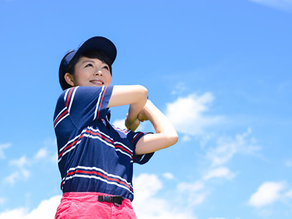 晴れの日にゴルフをする女性