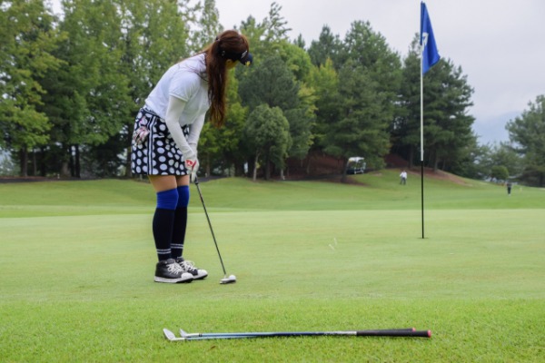 グリーン上でパッティングをする女性ゴルファー