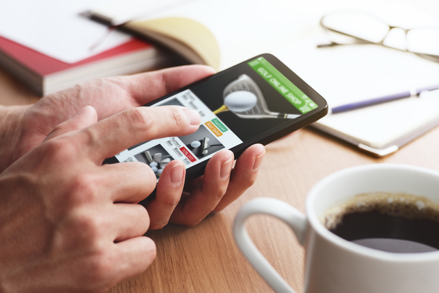 スマートフォンで相場を確認する人