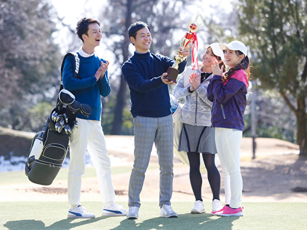 優勝トロフィーを掲げる男女グループ