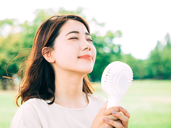 ハンディファンを使う女性