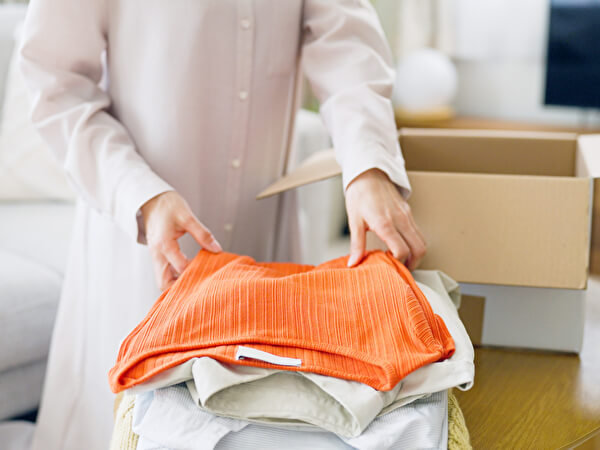 ダンボールに荷物を詰める女性